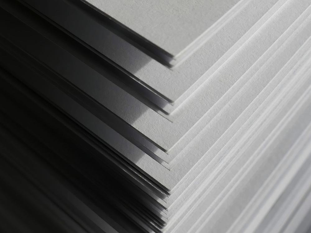 Close view of the edges of a stack of uncut paper stock.