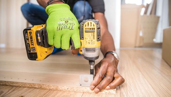 A cordless drill being used to fix a fitting into place during an installation.