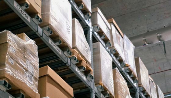 Warehouse racking stacked with cartons and palletized stock.